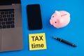 Tax time - notification of the need to file tax returns, tax form at accauntant workplace. Piggy bank in pink color with