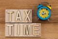 Tax time - text in vintage letters on wooden blocks with alarm Royalty Free Stock Photo