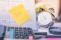 Tax word note on calendar, alarm clock and calculator on table