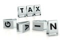 TAX word written on glossy blocks and fallen over blurry blocks with GAIN letters. Isolated on white. High taxes reduces companies