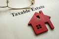 Taxable estate. House model and glasses on paper. Royalty Free Stock Photo