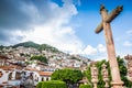 Taxco, Mexico - October 29, 2018. Cross in front of cathedral and houses in Mexican famous touristic city Royalty Free Stock Photo