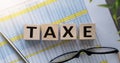 Taxe text on wooden block on sheet with calculations and points Royalty Free Stock Photo