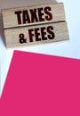 Taxes and fees Text on the wooden blocks, magenta pink paper. Business concept Royalty Free Stock Photo