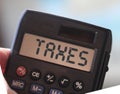 Taxes word on Calculator display, defocused sky and beach landscape. Tax and fees business concept Royalty Free Stock Photo