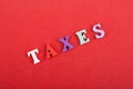 TAXES word on red background composed from colorful abc alphabet block wooden letters, copy space for ad text. Learning english Royalty Free Stock Photo