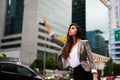 Taxi. an attractive young businesswoman hailing for a cab in the city during the day. Royalty Free Stock Photo