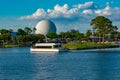 Taxi boat sailing and panoramic view of sphere Spaceship Earth attraction at Epcot in Walt Disney World .