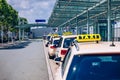 Taxi cabs waiting for passengers. Yellow taxi sign on cab cars. Taxi cars waiting arrival passengers in front of Airport Gate. Royalty Free Stock Photo