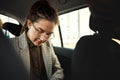 Taxi, car and business woman travel or commute in a vehicle ride and transport backseat in the morning to work. City Royalty Free Stock Photo