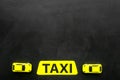 Taxi concept. Yellow service sign text taxi near car toy on black background top view copy space