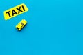 Taxi concept. Yellow service sign text taxi near car toy on blue background top view space for text