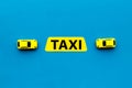 Taxi concept. Yellow service sign text taxi near car toy on blue background top view space for text