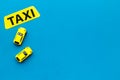 Taxi concept. Yellow service sign text taxi near car toy on blue background top view space for text