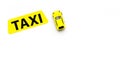 Taxi concept. Yellow service sign text taxi near car toy on white background top view copy space