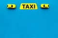 Taxi concept. Yellow service sign text taxi near car toy on blue background top view space for text
