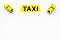 Taxi concept. Yellow service sign text taxi near car toy on white background top view space for text