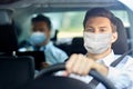 Taxi driver in face protective mask driving car