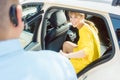 Taxi driver helping woman passenger out of the car