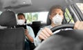Taxi driver in mask driving car with passenger Royalty Free Stock Photo