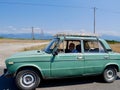 Taxi driver in turquoise vintage car on the road. Georgia.