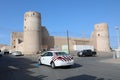 A taxi drives past As Suwayq Castle, Oman