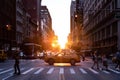 Taxi driving through a busy intersection past the people in the intersection of 5th Avenue and 23rd Street in New York City with Royalty Free Stock Photo