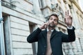 Taxi. a handsome businessman hailing a cab while making a phonecall.