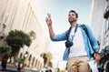 Taxi. a handsome young man hailing a cab while exploring a foreign city. Royalty Free Stock Photo