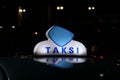 Taxi light sign or cab sign in blue and white color on the car roof at the street in the dark night