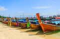 Taxi long-tail boats wait for tourists on beach, sunny day