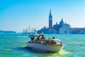 Taxi motoboat with masquerade passengers speeding in Venice lagoon Italy Royalty Free Stock Photo