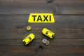 Taxi operator concept. Chip service. Price of services. Sign taxi ner car toy and coins on dark wooden background top