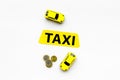 Taxi operator concept. Chip service. Price of services. Sign taxi ner car toy and coins on white background top view