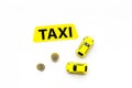 Taxi operator concept. Chip service. Price of services. Sign taxi ner car toy and coins on white background top view