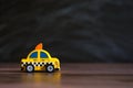 Taxi operator concept. Price of services. Yellow car toy taxi on black background