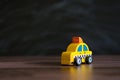Taxi operator concept. Price of services. Yellow car toy taxi on black background
