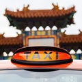 Taxi sign of a London taxi in front of the Chinatown gate in London