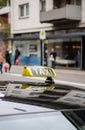 Taxi sign waiting for customers in city with defocused pedestrians