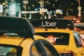 Taxi stand with Uber yellow cabs at night