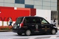 Taxi featuring Tokyo Olympic logo and Olympic-design fence