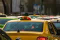 Taxi in traffic at rush hour stopped at red light. Car pollution, traffic jam in the morning and evening in the capital city of Royalty Free Stock Photo