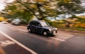Taxi vehicle in Edinburgh, Scotland. Panning photo with the car on the move with blurry background.