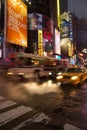 Taxis and buses pass by on busy street at Times Square, Manhattan Royalty Free Stock Photo