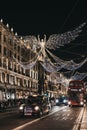 Taxis and buses under angel Christmas lights on Regent Street, London, UK, in the evening, motion blur