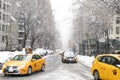 Taxis and cars driving down a snow covered 5th Avenue during a winter blizzard scene in New York City Royalty Free Stock Photo