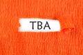 TBA the text under the torn paper is orange on a white background Royalty Free Stock Photo