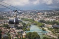 Tbilisi aerial tramway on cable above city and the Mtkvari -Kura River and Peace pedestrian bridge with Cacuses mountains on