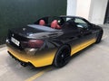 Tbilisi, Georgia - April 9, 2023: convertible car BMW with black and yellow paint design Royalty Free Stock Photo