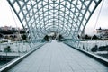 TBILISI, GEORGIA - January 08, 2023: People waling along the Bridge of peace. The modern architecture and famous landmark in